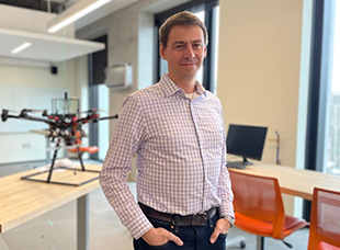 Professor Waslander standing in front of a drone model