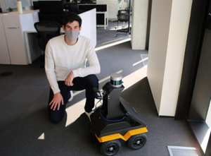 Student kneeling next to autonomous robot