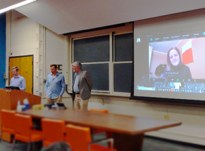 Tim Barfoot, Cameron Dickinson and Chris Damaren presenting at the lecture hall with Mona Gridseth on the video screen