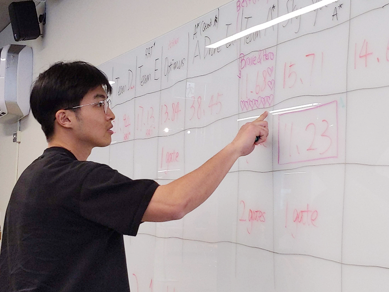 Student evaluating results of the UAV flight test on the whiteboard