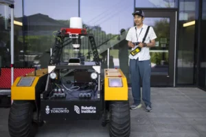 Aoran Jiao standing next to a rover