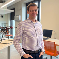 Professor Waslander standing in front of a drone model